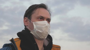 Salgın hayatta kalma konsepti. Virüs ve bakterilere karşı koruma. Gün batımında koruyucu bir tıbbi maske takan özgür bir adam. Sağlık ve güvenlik konsepti, koronavirüs N1H1, koruma.