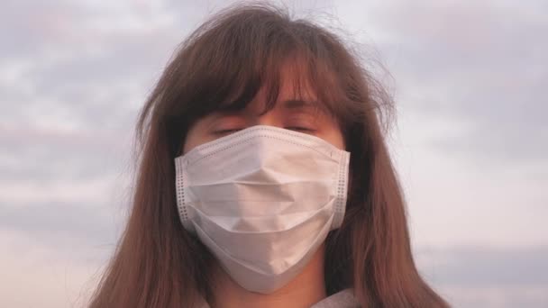 Protection against viruses and bacteria. pandemic survival concept. free woman wearing a protective medical mask in sunset light. health and safety concept, coronavirus N1H1, protection. — Stock Video