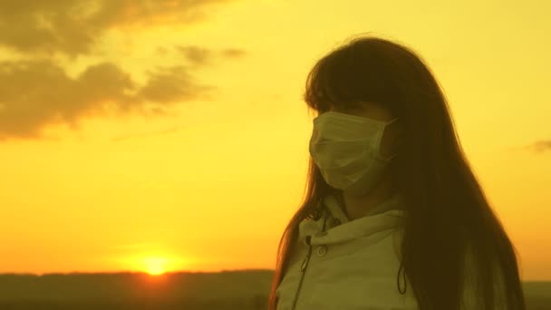 Concetto di sopravvivenza pandemica. donna libera che indossa una maschera medica protettiva alla luce del tramonto. Protezione contro virus e batteri. concetto di salute e sicurezza, coronavirus N1H1, protezione . — Video Stock