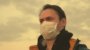 Sağlık ve güvenlik konsepti, koronavirüs N1H1, koruma. Salgın hayatta kalma konsepti. Virüs ve bakterilere karşı koruma. Özgür adam gün batımında koruyucu bir tıbbi maske takıyor..