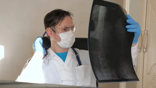 Läkaren på kontoret undersöker en röntgen av patienten på sjukhuset. En läkare arbetar på ett sjukhus kontor. Medicinsk vård och sjukvård koncept. behandling med coronavirus pandemi, pneumoni COVID-19 — Stockfoto