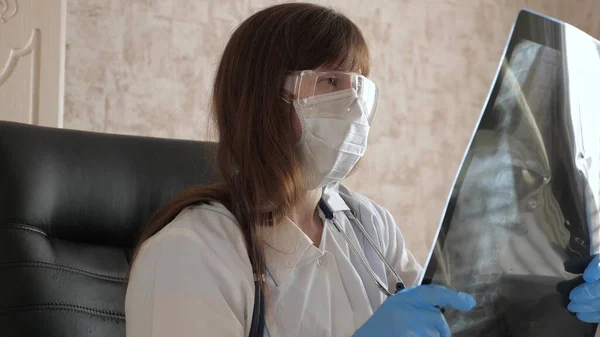 女性医師が病院でX線検査をしています。コロナウイルスパンデミック肺炎COVID-19治療。医者は病院で働いている。医療とヘルスケアの概念. — ストック写真