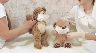 Çocuklar oyuncaklarla oynar, ayılar tıbbi koruyucu maskelerle dans eder. Çocuklar hastanede oynarlar. Oyun doktor, hemşire, veteriner gibi davranır, aşısı olan bir hastayı tedavi eder..