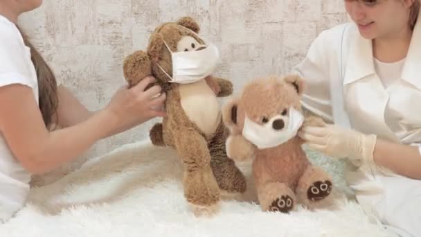 Les enfants jouent avec des jouets, les ours dansent avec des masques de protection médicale. les enfants jouent à l'hôpital. game fait semblant d'être médecin, infirmière, vétérinaire, traite un patient avec un vaccin . — Video