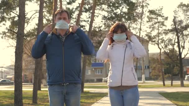Υγιές κορίτσι και ο άνθρωπος φορώντας μια προστατευτική μάσκα στο δρόμο, δείχνει ok. ελεύθεροι άνθρωποι φορούν ιατρική μάσκα για ιούς. Έννοια υγείας και ασφάλειας για τον πανδημικό coronavirus, coronavirus N1H1, προστασία από ιούς — Αρχείο Βίντεο