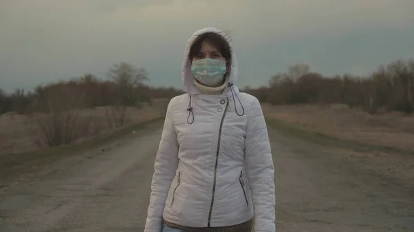 보호 마스크를 쓴 무료 여성 관광객 이 도시 밖 도로를 걷고 있습니다. 전염병 코로나 바이러스. 건강 한 소녀는 바이러스와 박테리아로부터 보호 한다. 건강 과 안전의 개념, 코로나 바이러스 — 스톡 사진