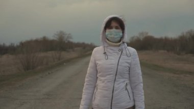 Özgür tıbbi maskeli kadın turist şehir dışında yürüyor. Salgın Koronavirüs. Virüs ve bakterilere karşı sağlıklı kız koruması. Sağlık ve güvenlik kavramı, koronavirüs