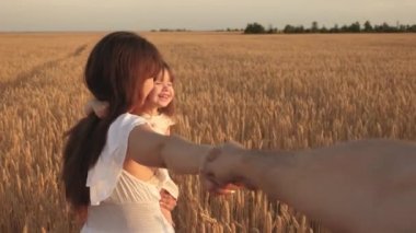 Özgür, çocuklu, mutlu ve genç bir aile yazın sahada geziyor. Sağlıklı anne, baba ve küçük kız çocukları birlikte doğanın tadını çıkarıyorlar. Ağır çekim. Benimle el ele gelin.