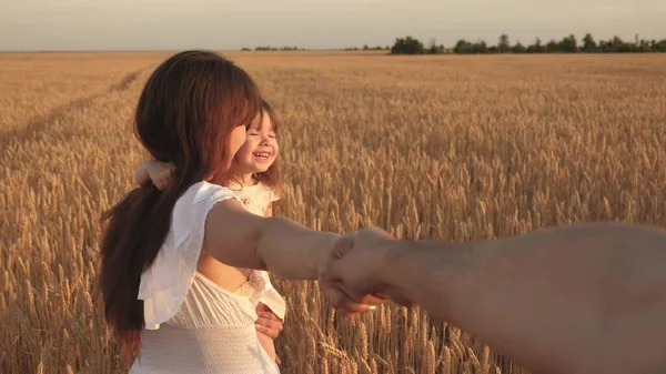 Feliz familia joven libre con un niño viaja en el verano en el campo. Hijas sanas de madre, padre e hija disfrutando de la naturaleza juntos, al aire libre. En cámara lenta. ven conmigo de la mano —  Fotos de Stock