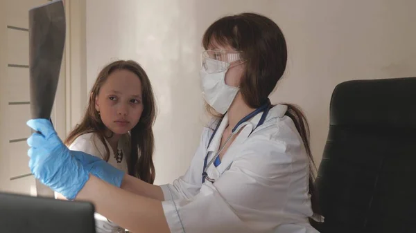 入院中の女性医師小児科医は、入院中の患者のX線を検査する。医者は病院で働いてる。医療と医療の概念。コロナウイルスパンデミック肺炎COVID-19 — ストック写真
