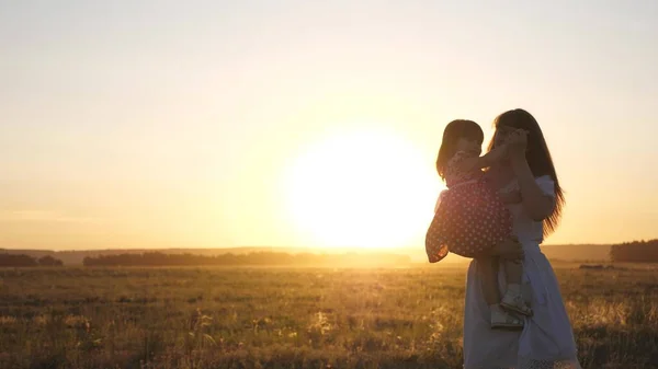 Darmowa mama i córeczka tańczą o zachodzie słońca. Matka i zdrowe dziecko w ramionach na polu. koncepcja szczęśliwego dzieciństwa. szczęśliwe dziecko bawi się z matką o zachodzie słońca. szczęśliwa koncepcja rodziny — Zdjęcie stockowe