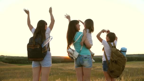 Darmowe kobiety podróżują z plecakami machają rękami i cieszą się zachodem słońca. Koncepcja przygody i podróży. Zdrowa mama i turyści. Dziewczyny podróżują. Turystka. matka z córkami podróżnych — Wideo stockowe