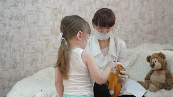 Gezonde kinderen spelen met een medische spuit met een beschermend masker. injecties voor paarden- en berenspeelgoed. wild doet zich voor als arts, verpleegster, behandelt patiënt met vaccin. kind speelt in ziekenhuis. — Stockfoto