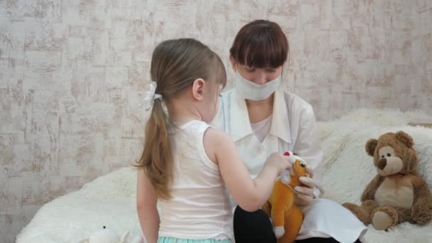 Healthy children play with a medical syringe in a protective mask. injections for horse and bear toys. game pretends to be doctor, nurse, treats patient with vaccine. child plays in hospital. — Stock Video