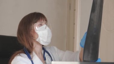 Ofisteki kadın doktor, hastanede bir hastanın çocuğunun röntgenini çekiyor. Doktor hastanede çalışıyor. Tıbbi bakım ve sağlık hizmeti kavramı. Koronovirüs salgını, zatürree.