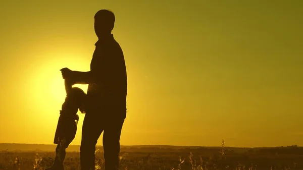 Padre e hija pequeña giran en la danza al atardecer. concepto de la infancia feliz. Papá está bailando con un niño en sus brazos. niño feliz juega con su padre al atardecer. concepto de una familia feliz — Foto de Stock