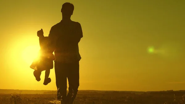 Ojciec i córka wirują w tańcu o zachodzie słońca. koncepcja szczęśliwego dzieciństwa. Tata tańczy z dzieckiem w ramionach. szczęśliwe dziecko bawi się z ojcem o zachodzie słońca. koncepcja szczęśliwej rodziny — Zdjęcie stockowe