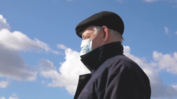 Risk of infection. An elderly man in the street in a medical mask. Pandemic coronavirus. man wears a protective mask on street. health concept, quarantine of coronavirus N1H1, virus protection. — Stock Video