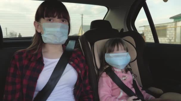 Mulher jovem saudável em máscara médica estéril protetora dirige um carro. conceito de coronavírus pandêmico. menina livre viaja em uma máscara em um carro. proteção contra vírus e bactérias. uma menina monta um carro — Vídeo de Stock