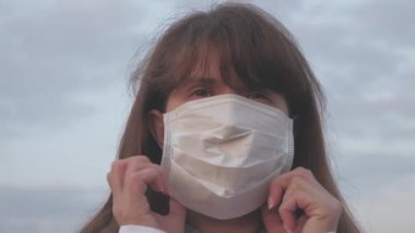Özgür sağlıklı bir kadın sokakta koruyucu bir tıbbi maske takar. Virüs ve bakterilere karşı koruma. Sağlık ve güvenlik konsepti, koronavirüs N1H1, koruma. Maskeli turist kız