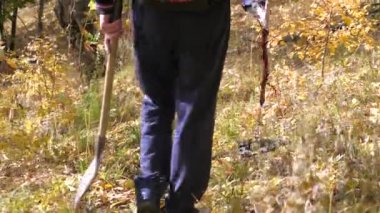 Maceraperest bir kürekle hazine aramaya gider. Metal dedektörlü bir adam hazine arıyor. Sahada metal araştırması yapan metal dedektörü. mayın temizliği.