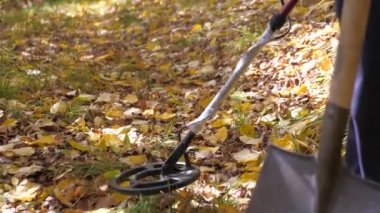 Maceraperest bir kürekle hazine aramaya gider. Metal dedektörlü bir adam hazine arıyor. Sahada metal araştırması yapan metal dedektörü. mayın temizliği.