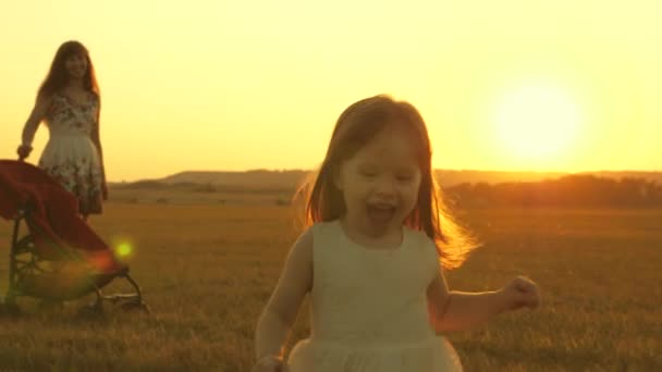 Criança feliz e pais caminham ao pôr-do-sol. O pai abraça a filha e gira em voo. Silhueta de uma família que anda ao sol. Mãe pai e bebé. O conceito de uma família feliz. Estilo de vida familiar — Vídeo de Stock