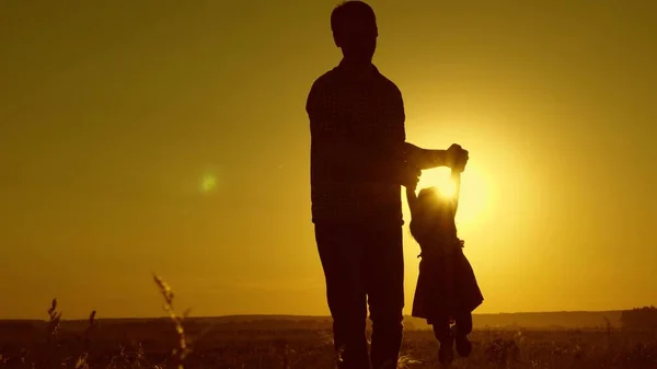 Здоровый отец и маленькая дочь танцуют на закате. концепция счастливого детства. Папа танцует с ребенком на руках. счастливый ребенок играет со своим отцом на закате. Концепция счастливой свободной семьи — стоковое фото