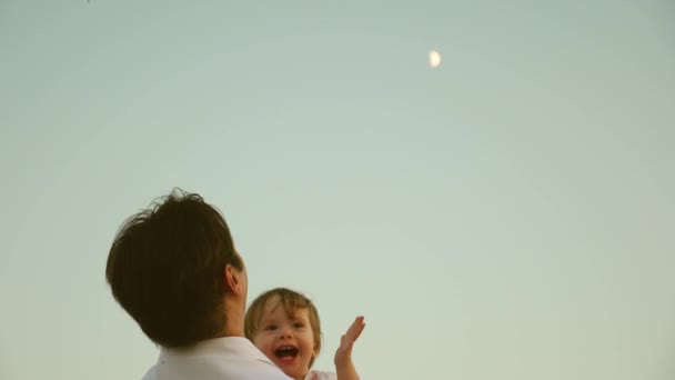 Pai livre lança uma filha feliz no céu azul viagens familiares felizes. pai saudável e filhinha brincam, riem e abraçam. Bebê nos braços dos pais. conceito de família feliz. O pai está de folga . — Vídeo de Stock