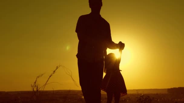 Pai saudável e filhinha rodopiam em dança ao pôr do sol. conceito de infância feliz. O pai está a dançar com a criança nos braços dela. criança feliz brinca com seu pai ao pôr do sol. conceito de família livre feliz — Vídeo de Stock