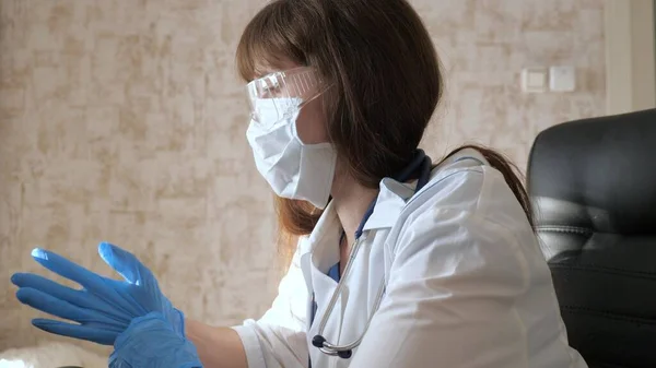 远程医疗，远程医疗的概念。穿着白色外套和安全眼镜的女医生在笔记本电脑上工作，进行在线咨询和会议。医生使用虚拟机与客户进行交流 — 图库照片