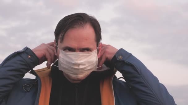 Безкоштовний чоловік-мандрівник носить захисну медичну маску під час заходу сонця. турист у захисній масці. Концепція охорони здоров'я та безпеки, захист від коронавірусу N1H1. Захист від вірусів і бактерій . — стокове відео