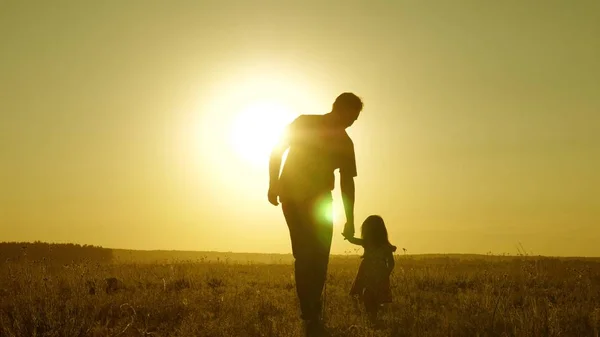 Hija Pequena Y Papa Caminan Por El Campo Tomados De La Mano Nino Sostiene A Los Hija Pequena Y Papa Caminan Por El Campo Tomados De La Mano Nino Sostiene A Los