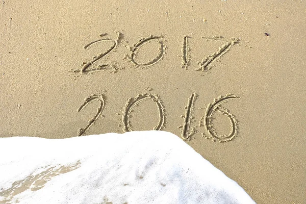 Good bye 2016 hello 2017. inscription written in the beach sand.