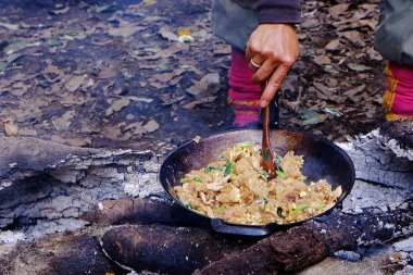 Ormanda ateşte yemek pişirmek. Tavada Kızarmış erişte Tay tarzı.
