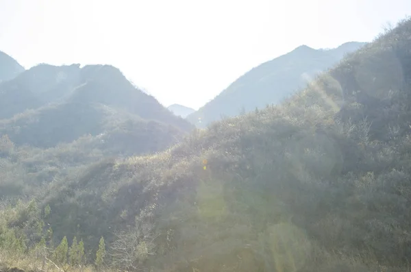 The sunny mountains of China. Beautiful vista of mountain hills. Mountains in a blue fog.