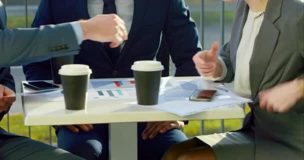 Співробітники сидять за столом на відкритому повітрі — стокове відео