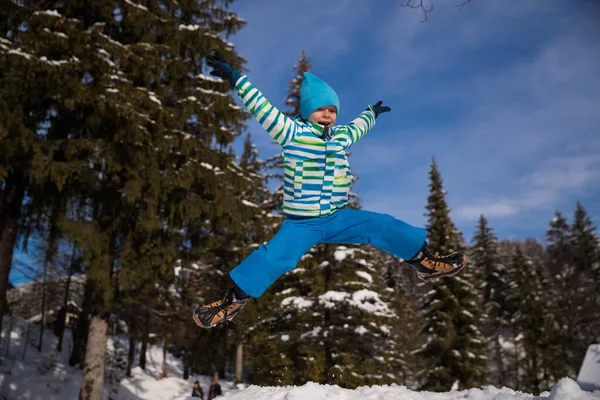 Ευτυχισμένο Αγόρι Που Πηδάει Ψηλά Στο Χιονισμένο Δάσος — Φωτογραφία Αρχείου