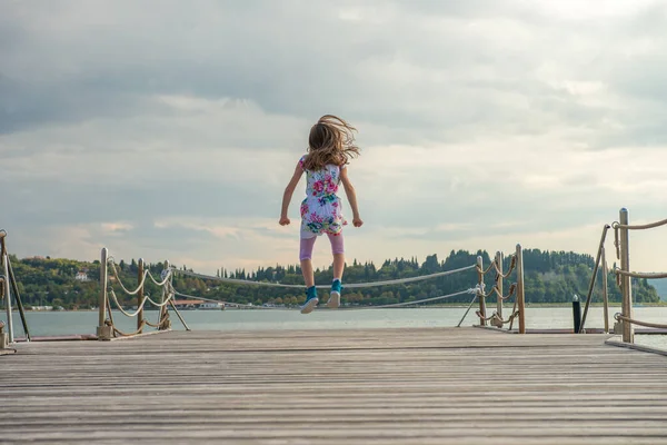 Girl Jumping High Air Next Ocean — kuvapankkivalokuva