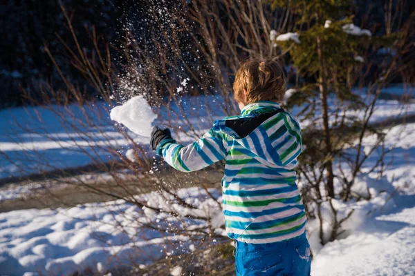 Sun Flared Little Boy Throwing Snowball Royalty Free Stock Images