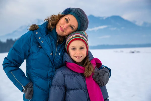 Mother Hugging Her Daughter Snowy Landscape – stockfoto