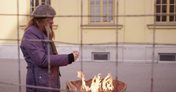 4K lento moo di senzatetto uomo e donna riscaldamento da il fuoco — Video Stock