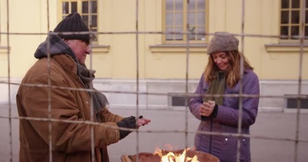 4K Slow Mo Of Homeless Couple Warming Up By The Fire — Stok Video