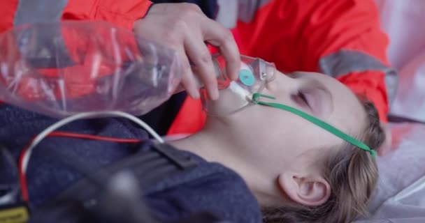 4K close-up van paramedici zetten zuurstof masker op kleine meisje — Stockvideo