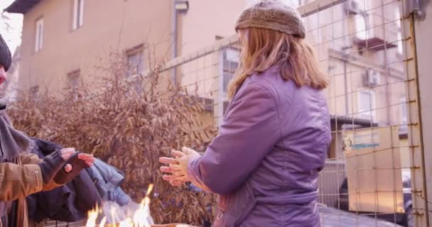 4K lenta Mo di coppia di senzatetto in piedi accanto al fuoco in un barile — Video Stock
