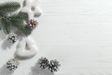 Christmas gingerbread cookies and pine branches and cones on a white background, copy space.