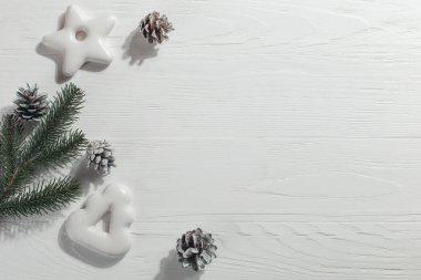 Christmas gingerbread cookies and pine branches and cones on a white background, copy space.