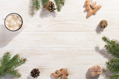 Hot Christmas drink with marshmallows in an iron mug and gingerbread cookies, on a white table. New Year, holiday background, greeting card copy space.