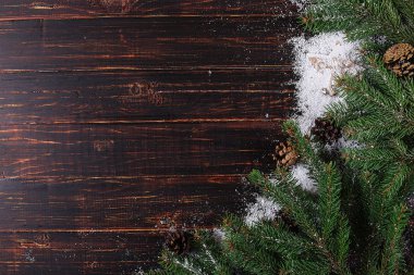 Christmas background, Fir-trees and cones on a wooden table, cru
