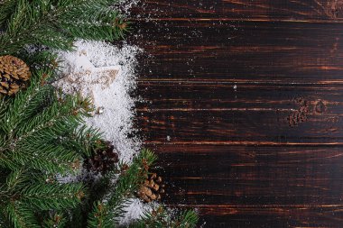 Christmas background, Fir-trees and cones on a wooden table, cru